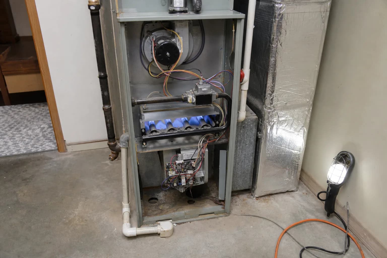 Gas furnace being serviced in a Fairhope home back room, filter detail