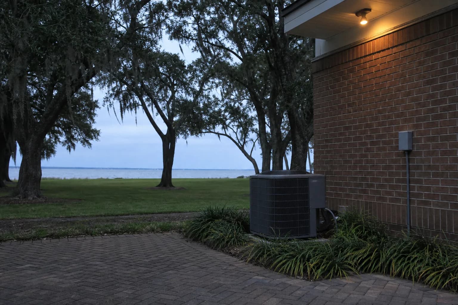 AC condenser being serviced at a Lillian Mobile Bay home, backyard view, fall
