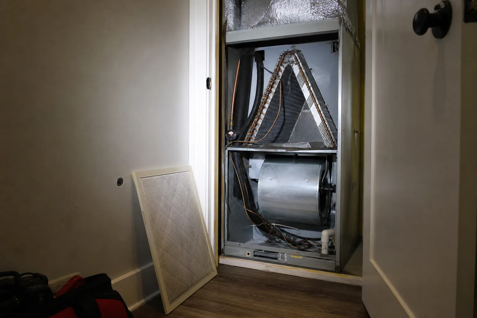 Indoor air handler being serviced in a Fairhope home bonus room, tune-up view