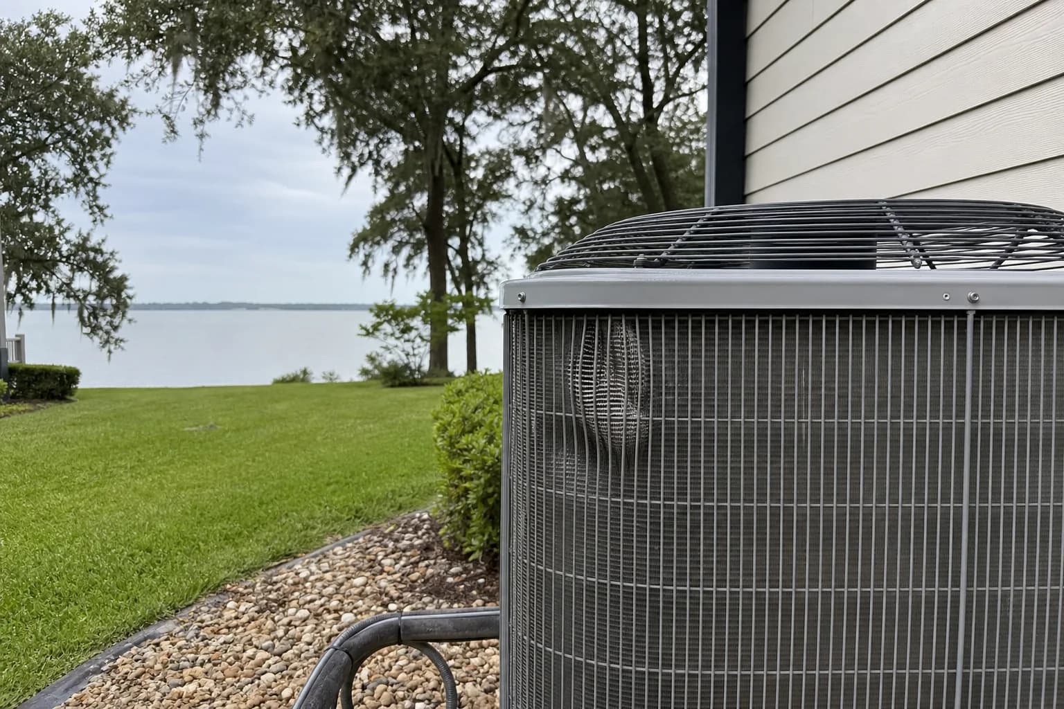 AC condenser being serviced at a Fairhope Mobile Bay home, close-up, summer