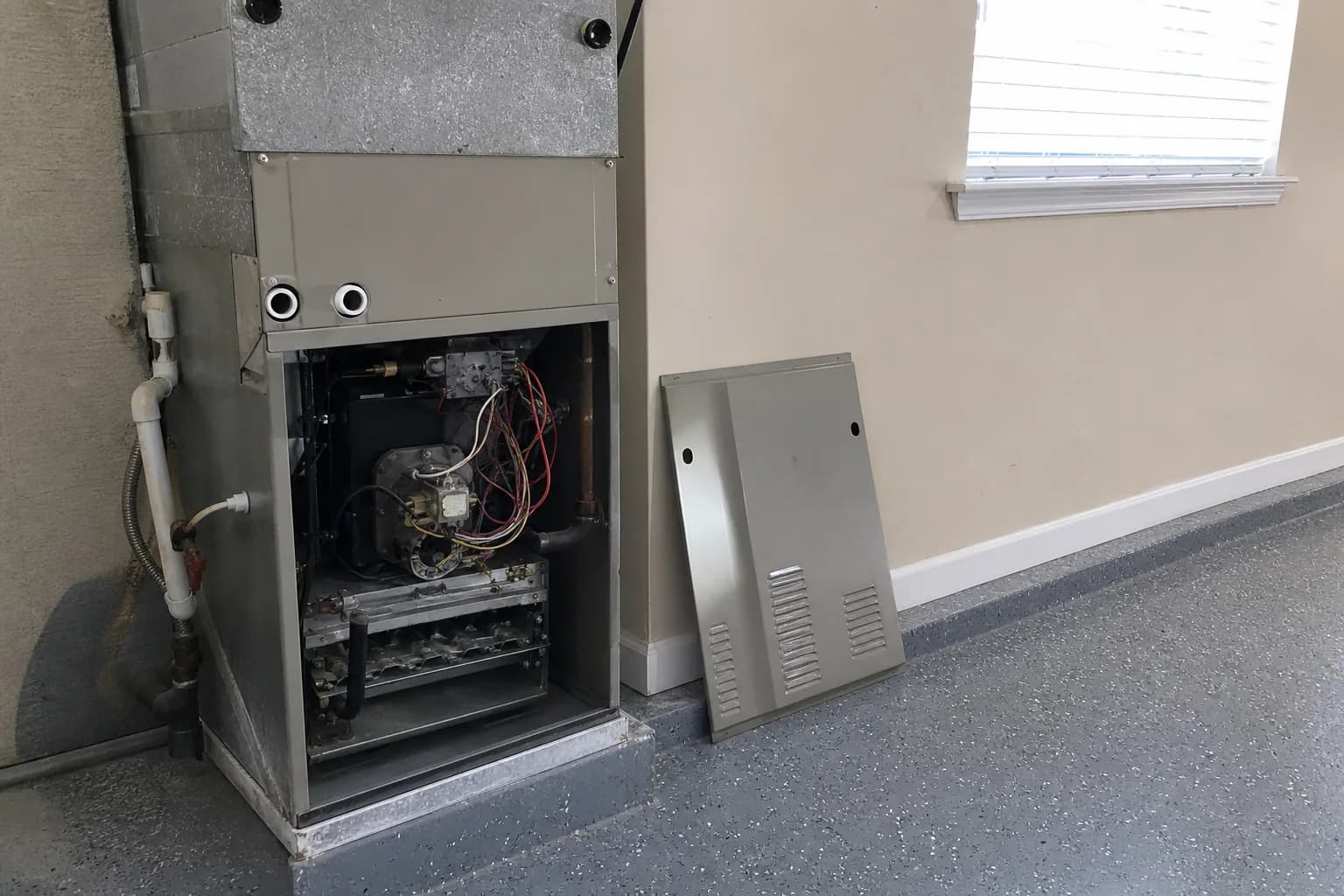 Gas furnace being serviced in a Bay Minette home garage, routine check