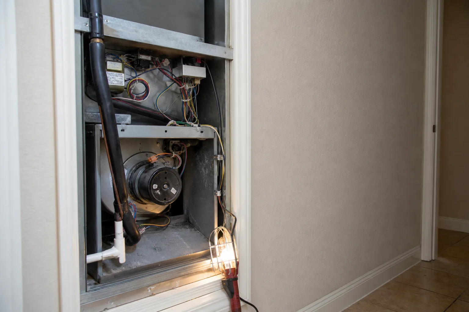 Indoor HVAC unit on an after-hours call in a Bay Minette home utility closet, service view