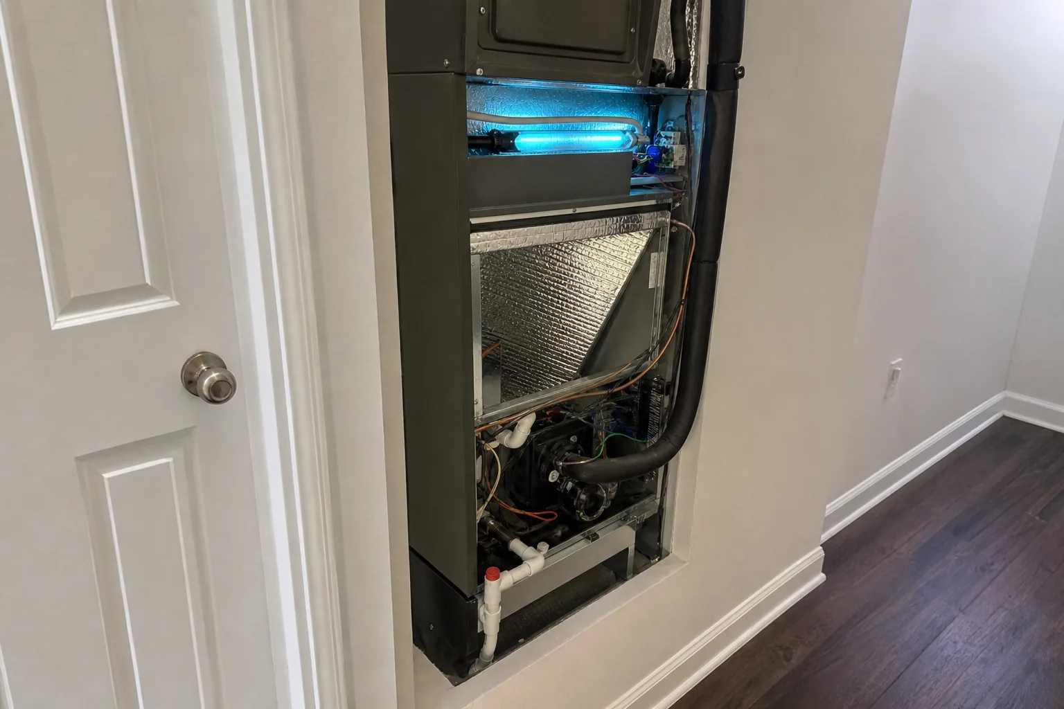 Indoor air-quality equipment in an Elberta home hallway, panel off