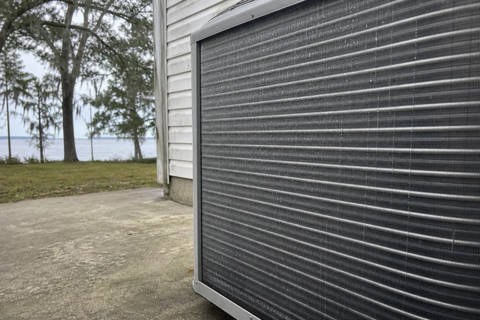 AC unit being maintained at a Lillian Mobile Bay home, fan-grille detail, fall