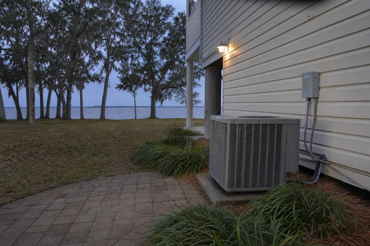 AC condenser being serviced at a Daphne Mobile Bay home, service view, summer